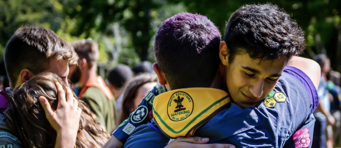 Dois jovens escoteiros se abraçando